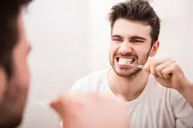 A young man brushing his teeth