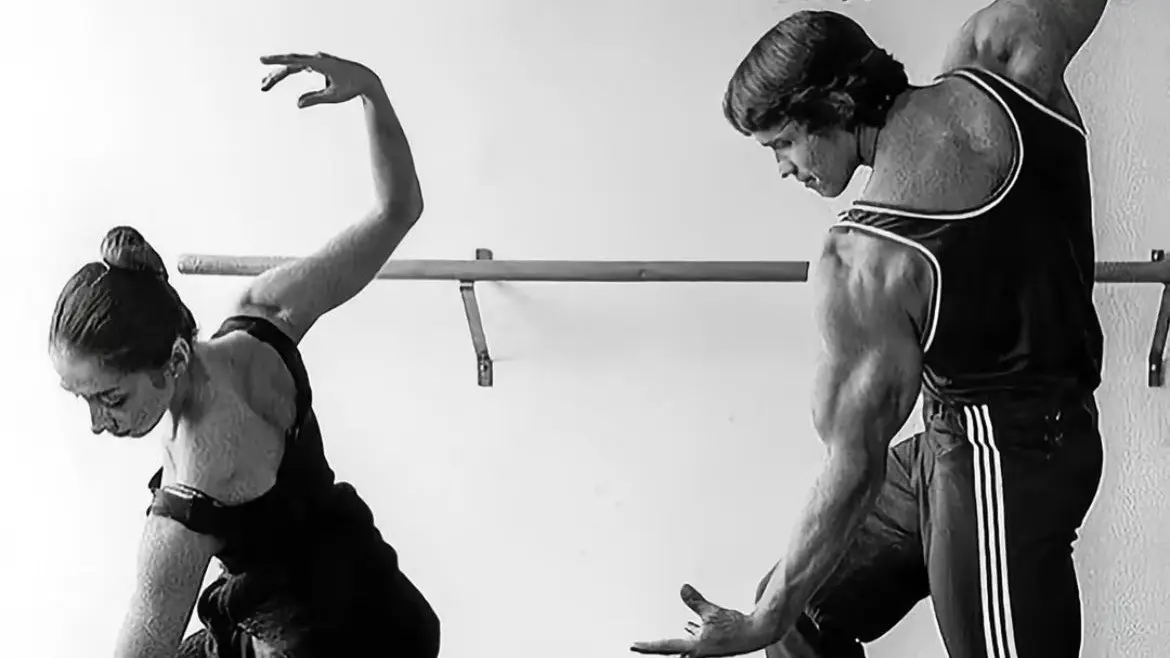 Arnold Schwarzenegger practicing ballet with a dancer, demonstrating his learning through struggle.