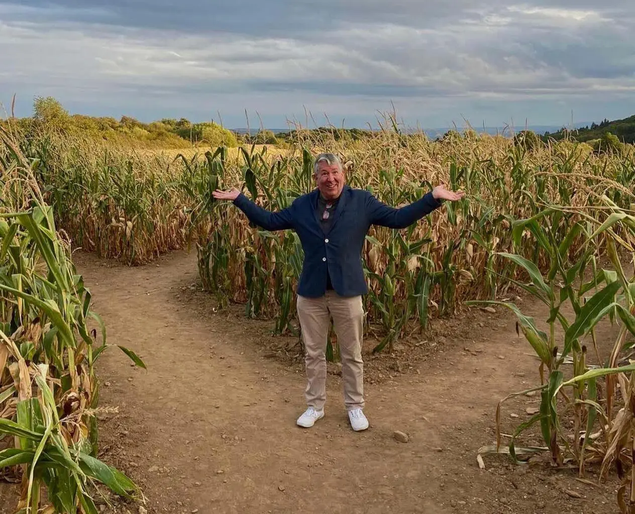 Daniel Ord standing at a fork in a corn maze, considering which direction to take.