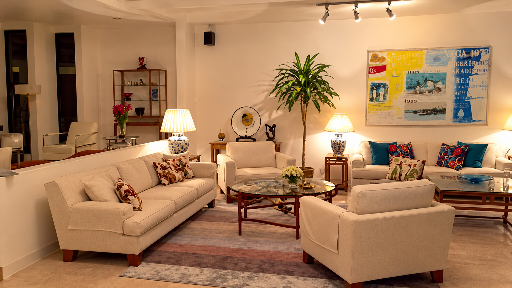 A beautifully decorated formal living room with elegant seating, warm lighting, artwork, and decorative objects, ready to welcome guests.